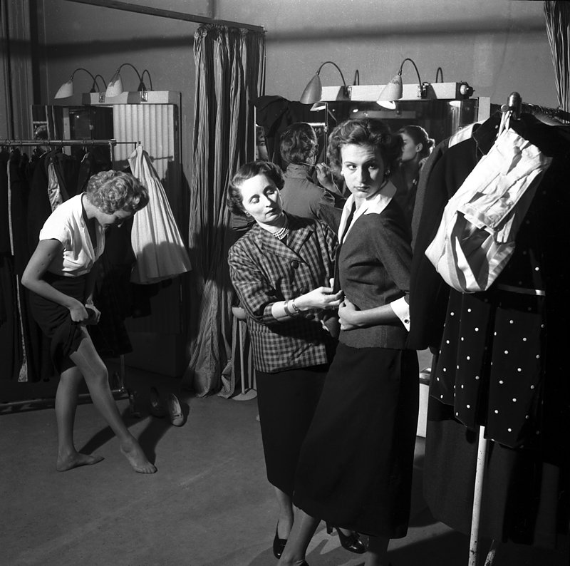 Milano, ottobre 1953. Collezione Biki dal servizio "Passeggiata di quattro modelle". Le modelle con la sarta nel suo atelier